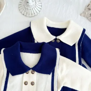 Detail view of toddler sailor style knit dress, navy and white collar with metal buttons.