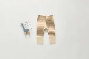 Detailed view of cute baby striped cotton leggings with ribbed cuffs in brown and white color.