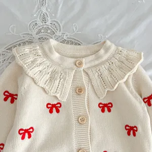 Cute baby girl knit cardigan with ruffled collar and red bow embroidery, soft cotton top.