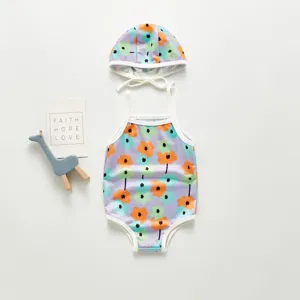 Kids one-piece swimsuit and matching swim cap with colorful floral print for summer beach holiday.