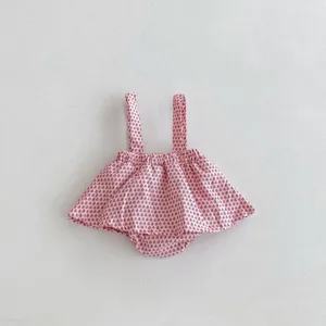 Close-up detail of infant baby pink printed strap romper skirt with cute ruffles.