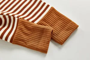 Infant striped trousers detail featuring soft ribbed brown cuffs, comfortable cotton fabric texture.
