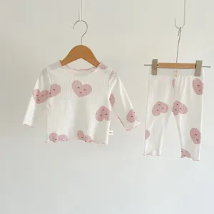 Detail shot of infant ribbed cotton pajama set featuring cute heart prints and lettuce trim details.