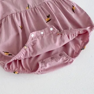 Vista detallada del pelele para bebé niña rosa con bordado de limón y botones a presión.