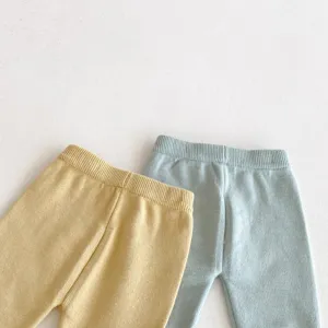 Dettaglio in primo piano pantaloni lavorati a maglia per neonati tessuto morbido ed elastico.