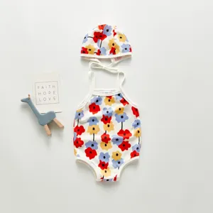 Cute floral baby girl one-piece swimsuit and matching swim cap set for beach vacation.