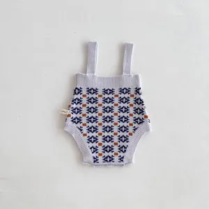 Infant knit romper detail view showing retro geometric patterns and soft straps texture.