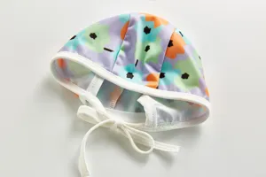 Colorful floral print kids swim cap with adjustable ties, perfect for summer beach vacations.