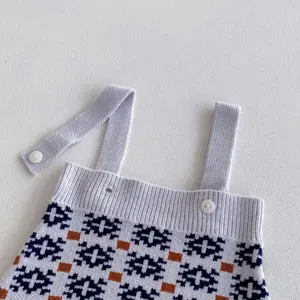 Infant knitted baby romper detail view, classic geometric pattern with cute buttons.