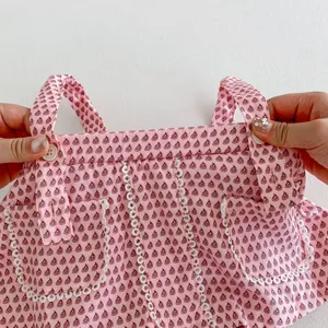 Cute infant baby girl pink floral printed strap dress detail with delicate lace trim pockets