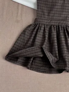Details of the cute baby plaid sleeveless dress, showing fine fabric and pleated skirt hem.