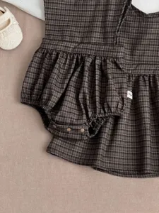 Infant baby girl brown plaid sleeveless romper dress detail showing ruffles and buttons.