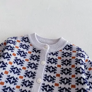 Detail shot of infant knitted cardigan sweater with geometric pattern and cute buttons.