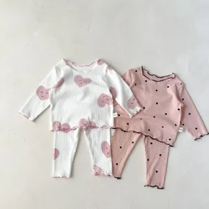 Infant ribbed cotton pajama detail showing lettuce hem and cute heart and polka dot prints.