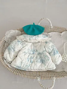 Detailed view of baby toddler quilted warm padded coat with lace collar and green beret.