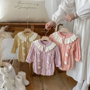 Detailed view of baby knit romper with floral ruffles and contrast collar for autumn.