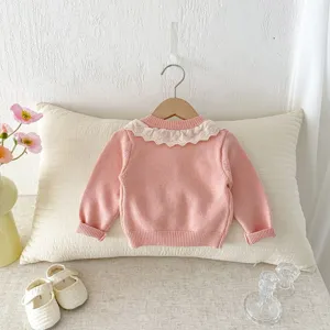 Leuke roze gebreide babyvestje voor meisjes met delicate witte kantkraag voor de herfst.