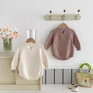 Vue détaillée de barboteuse bébé en maille douce, texture confortable et design à boutons.