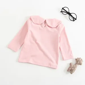 Dettaglio della maglietta rosa da neonata con colletto Peter Pan e chiusura sul retro.