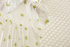Primer plano de camisa de verano de manga corta con flores para bebé y cuello.