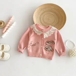 Gedetailleerd overzicht van roze gebreid vestje voor baby's met kantkraag en konijnenborduurwerk.