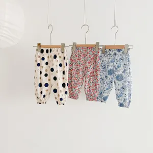 Baby mosquito repellent pants detail showing cute floral and dot prints on hanging toddler wear.