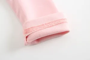Primo piano del polsino della t-shirt da neonato in cotone rosa, tessuto morbido e cuciture fini.