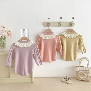 Detailed view of infant knitted baby romper with delicate ruffled collar and long sleeves.