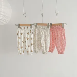 Detailed view of cute baby floral and bear print anti-mosquito pants hanging on wooden hangers.