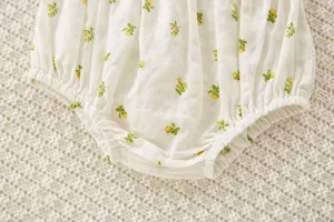 Detalle de braguita de algodón para bebé con estampado floral amarillo y cintura elástica.
