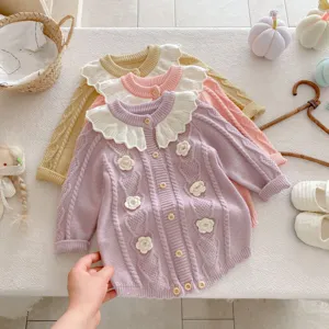 Detailed view of infant knit romper with lotus leaf collar and hand-crocheted floral decor.