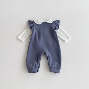 Detalle de mameluco de otoño para niña, bonito cuello blanco y tela acanalada gris azulada.