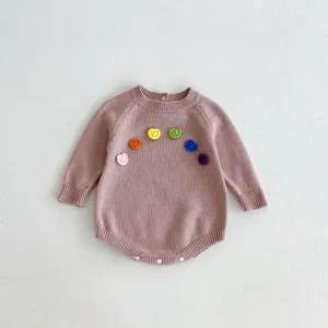 Détail de barboteuse tricotée bébé, fleurs crochetées, matière douce, body manches longues