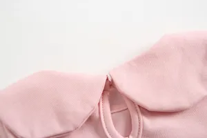 Dettaglio colletto top in cotone per bambina rosa, grazioso design a revers, tessuto morbido.