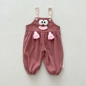 Detail view of cute baby corduroy overalls featuring 3d cartoon eyes and hands design.