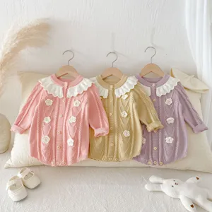 Infant knit romper detail featuring lotus collar and hand-crocheted flower decorations.