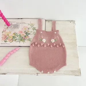 Infant pink knit romper detailed with floral embroidery and bobble details for cute baby style.