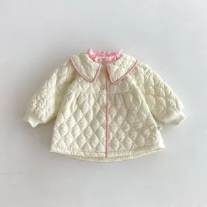 Toddler girl quilted jacket detail view featuring elegant pink ruffled collar and diamond pattern.