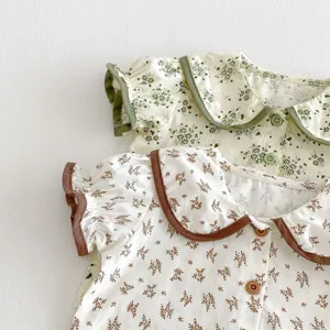 Detailed close-up view of baby floral doll collar short sleeve top with contrast trim.
