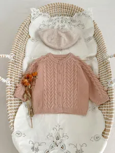 Baby gebreid vest set met schattige pompons en kabelbreisel voor de herfst.