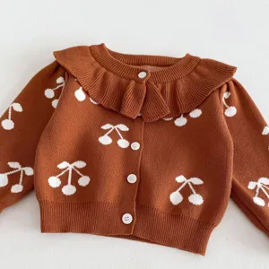 Baby girl brown knit cardigan detail showcasing white cherry pattern and ruffle collar.