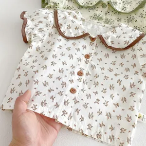 Infant baby floral doll collar short sleeve top with brown trim and wooden buttons.