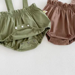 Detailed view of infant cotton suspender bloomers in green and brown with snap buttons.