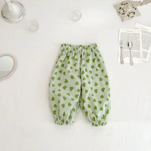 Close-up detail of infant green heart print casual bloomers pants with elastic cuffs.