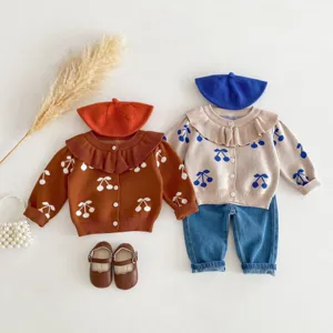 Detailed view of baby girl cherry print knit cardigan set with beret and denim pants flat lay.