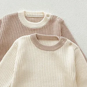 Detailaufnahme des weichen Baby-Strickpullovers mit Kragen und Schulterknöpfen.