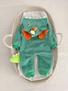 Dettaglio della tutina da dinosauro in peluche verde per neonato con morbido pile e cappuccio.