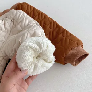 Gedetailleerd uitzicht op peuter winter gewatteerde jas stof en pluche voering in crème en karamel.