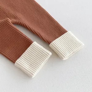 Primo piano dettaglio di leggings in maglia da neonato, polsini a coste e morbida.
