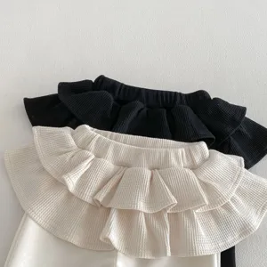 Detailed view of toddler girls waffle flare pants featuring layered ruffle waist design.